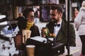 Attractive smart couple is enjoying coffee while sitting outside at small coffeesho