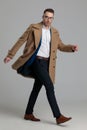 Attractive smartcasual guy wearing long coat walking