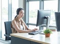 Attractive and smile young asian customer servicer woman wearing headset in modern creative meeting working office look at Royalty Free Stock Photo