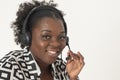 Attractive smiling black woman holding mouth piece of a headset.