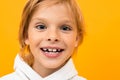 Attractive smiling blond boy in a white hoodie on a yellow background close-up Royalty Free Stock Photo