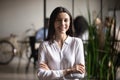 Attractive smiling businesslady standing with arms crossed looking at camera