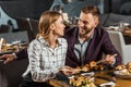 Attractive smiling couple amorously looking at each other while having dinner