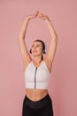 Attractive smiling girl doing stretching over pink background Royalty Free Stock Photo