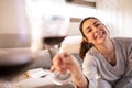 Attractive, smiling girl toasts with a glass of wine while enjoying a day off at home. Enjoying friendship and love during the Royalty Free Stock Photo