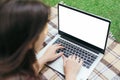 Attractive smiling girl works remotely behind a close-up laptop in a city park, lying on a plaid. A place for text. mock-up Royalty Free Stock Photo