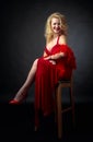 Attractive smiling mature woman  in red evening dress with fluffy feather boa Royalty Free Stock Photo