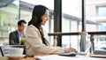 An attractive Asian businesswoman is working on her project on her laptop in the coffee shop Royalty Free Stock Photo