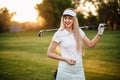Attractive smiling positive golfer girl in holding an irion in hand. Waiting for a good game of golf. Golf Club