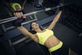 Attractive smiling sporty woman exercising with barbell in gym. Fitness and active lifestyle. Well-groomed bodybuilder Royalty Free Stock Photo