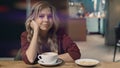 Attractive smiling woman in cafe dreaming and waiting for a meeting. looking directly to camera. Lense flare Royalty Free Stock Photo