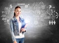 Attractive smiling woman in denim jacket holding notebooks and d