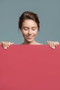 Attractive smiling woman holding red empty paper blank Royalty Free Stock Photo