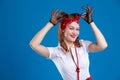 Attractive smiling woman in pin-up style , adjusts her headband, on an isolated blue background in the Studio Royalty Free Stock Photo