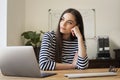 Attractive smiling woman sitting behind her laptop at home Royalty Free Stock Photo