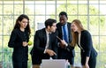 Attractive smiling young adult caucasian businessman leader discussing with the multiracial colleagues. CEO looking and pointing Royalty Free Stock Photo