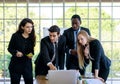 Attractive smiling young adult caucasian businessman leader discussing with the multiracial colleagues. CEO looking and pointing Royalty Free Stock Photo