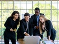 Attractive smiling young adult caucasian businessman leader discussing with the multiracial colleagues. CEO looking and pointing Royalty Free Stock Photo