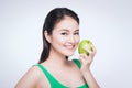 Attractive smiling young asian woman eating green apple isolated over white background Royalty Free Stock Photo