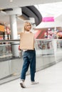 attractive smiling young woman holding paper bag at shopping Royalty Free Stock Photo