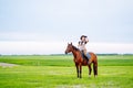 Attractive sport cowgirl horse woman with hat, holding harness, training. Horseback riding freshness, sky, grass meadow