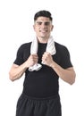 Attractive sport man with fit strong body holding towel around his neck with his hands smiling happy Royalty Free Stock Photo