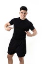 Attractive sport man pointing on his black t-shirt with copy space for adding gym fitness health club logo Royalty Free Stock Photo
