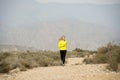 Attractive sport woman running on earth trail dirty road with desert mountain landscape background Royalty Free Stock Photo