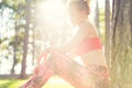 Attractive sportive woman wearing smart watch taking a break after workout session. Lifestyle image with strong lens flare