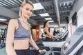 attractive sportive woman running on treadmill at gym