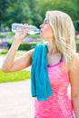 Attractive sporty blond woman drinking water