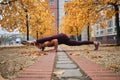 Attractive sporty girl in sportswear doing yoga exercises on empty street