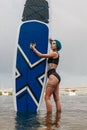 attractive sporty woman posing with paddleboard