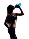 Attractive sporty young woman drinking from blue shaker bottle in studio. Silhouette photo. Isolated on white background.