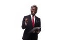 Attractive standing Afro American businessman writing notes and smiling at the camera isolated on white background Royalty Free Stock Photo