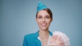 Attractive stewardess in uniform holds Russian rubles in her hand.