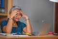 Attractive stressed and overworked Asian woman working at office laptop computer desk in stress feeling frustrated and upset in Royalty Free Stock Photo