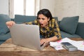 Attractive stressed woman managing finances, reviewing bank accounts, paying bills using laptop Royalty Free Stock Photo