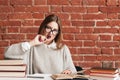 Attractive student girl biting pen at library Royalty Free Stock Photo