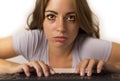 Attractive student girl or working woman sitting at computer desk in stress with tired red eyes after long hours working looking a Royalty Free Stock Photo