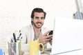 Attractive student or hipster style freelancer businessman working with laptop computer and mobile phone Royalty Free Stock Photo