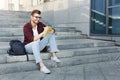 Attractive student making notes sitting on stairs outdoors Royalty Free Stock Photo