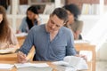 Attractive student studying with textbook in classroom, writing notice Royalty Free Stock Photo