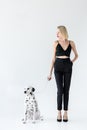 attractive stylish blonde woman in black clothes holding dalmatian dog leash Royalty Free Stock Photo