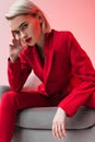 attractive stylish elegant woman in red clothes posing in armchair, Royalty Free Stock Photo