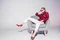 attractive stylish girl posing on armchair for fashion shoot, Royalty Free Stock Photo