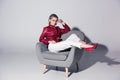 attractive stylish girl posing on armchair for fashion shoot, Royalty Free Stock Photo