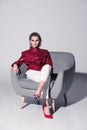 attractive stylish girl posing on armchair for fashion shoot, Royalty Free Stock Photo