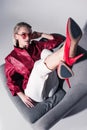 attractive stylish girl in red heels posing on armchair, Royalty Free Stock Photo