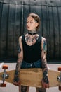 attractive stylish tattooed girl with closed eyes holding